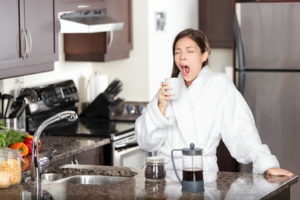 Yawning coffee woman in morning